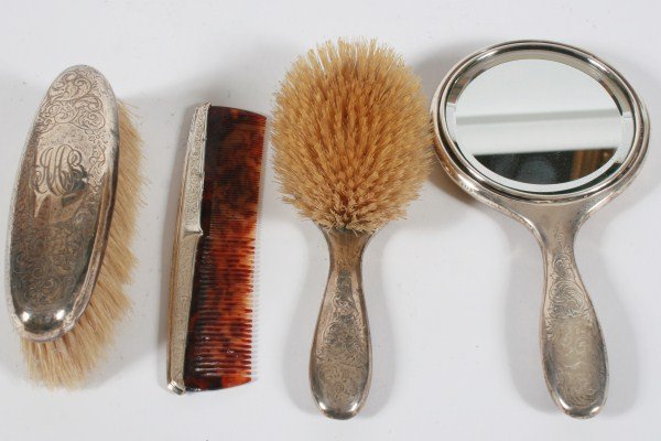 Four Piece Sterling Silver Dresser Set: Four piece sterling sliver dresser set. Hand chased dresser set includes a clothes brush, a comb, a hair brush, and a hand mirror. Provenance: From the Estate of Stephen Stackpole.
