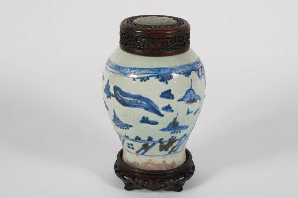 Chinese Blue and White Porcelain Vase: Chinese blue and white porcelain vase. Circa 1780. Having a pierced wooden cover inset with jade. Raised on a carved teakwood base. Height 13", diameter 6 1/2". Provenance: From the Estate of Stephen 