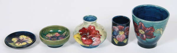 Five Pieces of Moorcroft Pottery: Five pieces of Moorcroft party. Lot includes three vases, one bowl, and one miniature plate. Each piece decorated with painted floral designs. Height of tallest 3 1/2".