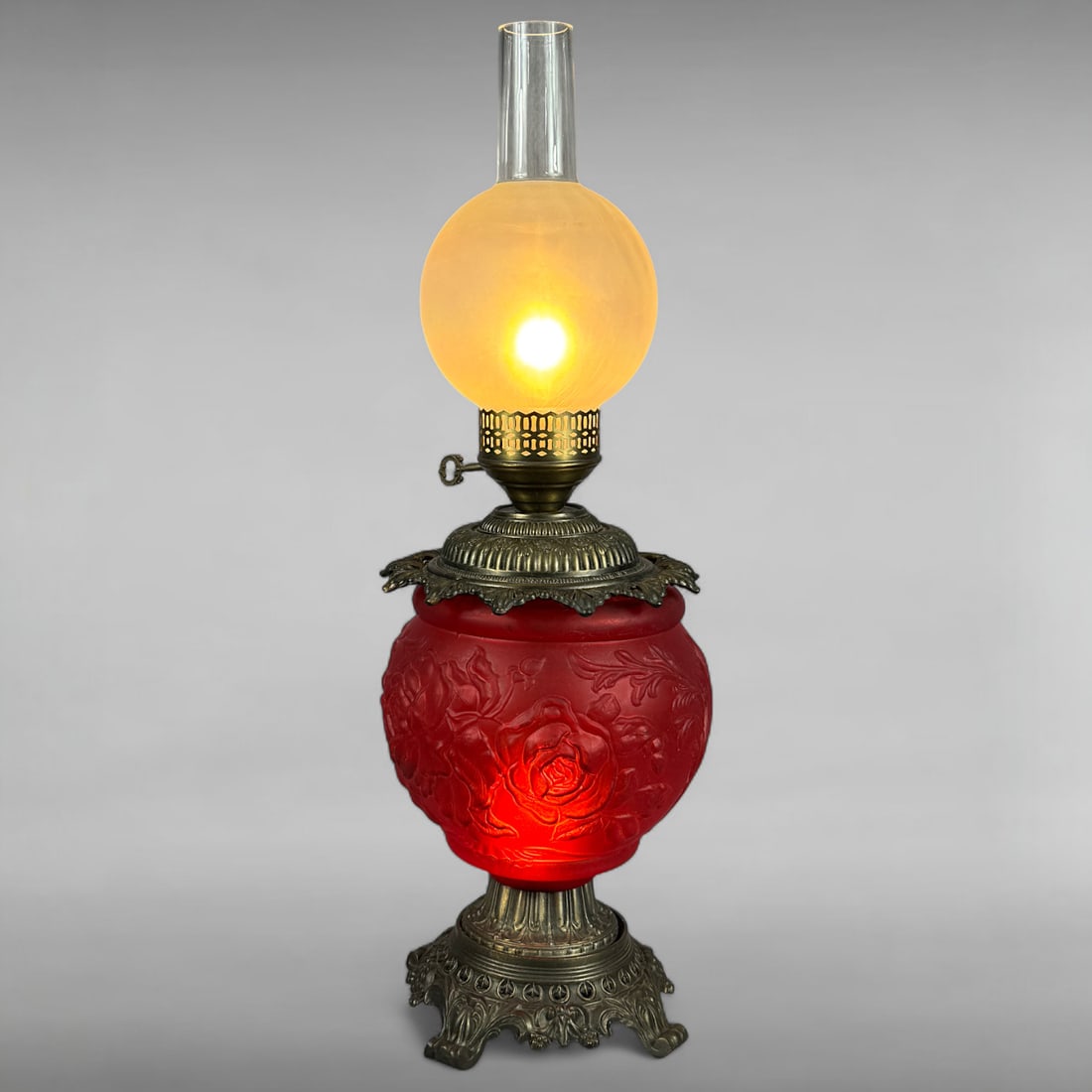 Gone with the Wind style of parlor lamp: Converted Oil Lamp • Frosted Red Glass Base • Frosted Hurricane Globe • Antique Brass This antique oil lamp, converted to electric, features a vibrant frosted red glass base embossed wi
