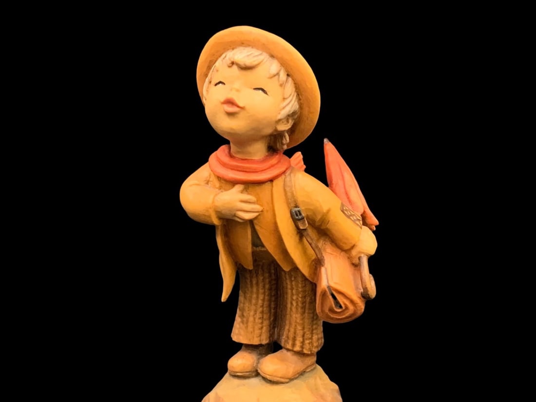 ANRI The Introduction Carved Figurine by Ferrandiz: ANRI The Introduction by Ferrandiz Anri- Italy Have You Heard figurine Figurine depicts a young boy wearing a hat, scarf, jacket carrying a bag and umbrella. Ferrándiz's figurines, produced by ANRI, 
