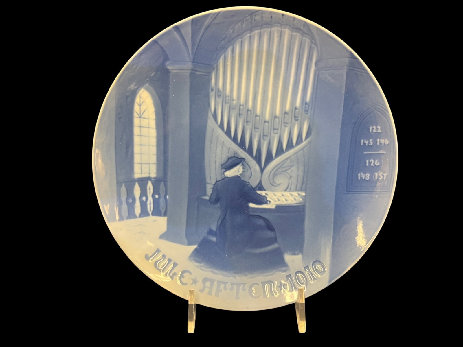 The Old Organist, 1910 Bing & Grondahl Christmas Plate: The Old Organist, 1910 Bing & GrondahlPorcelain ChristmasPlate Title: The Old Organist Christmas Plate Designed by: C. Ersgaard Color: Blue and White Type: Porcelain (Underglaze) Markings on Bottom of