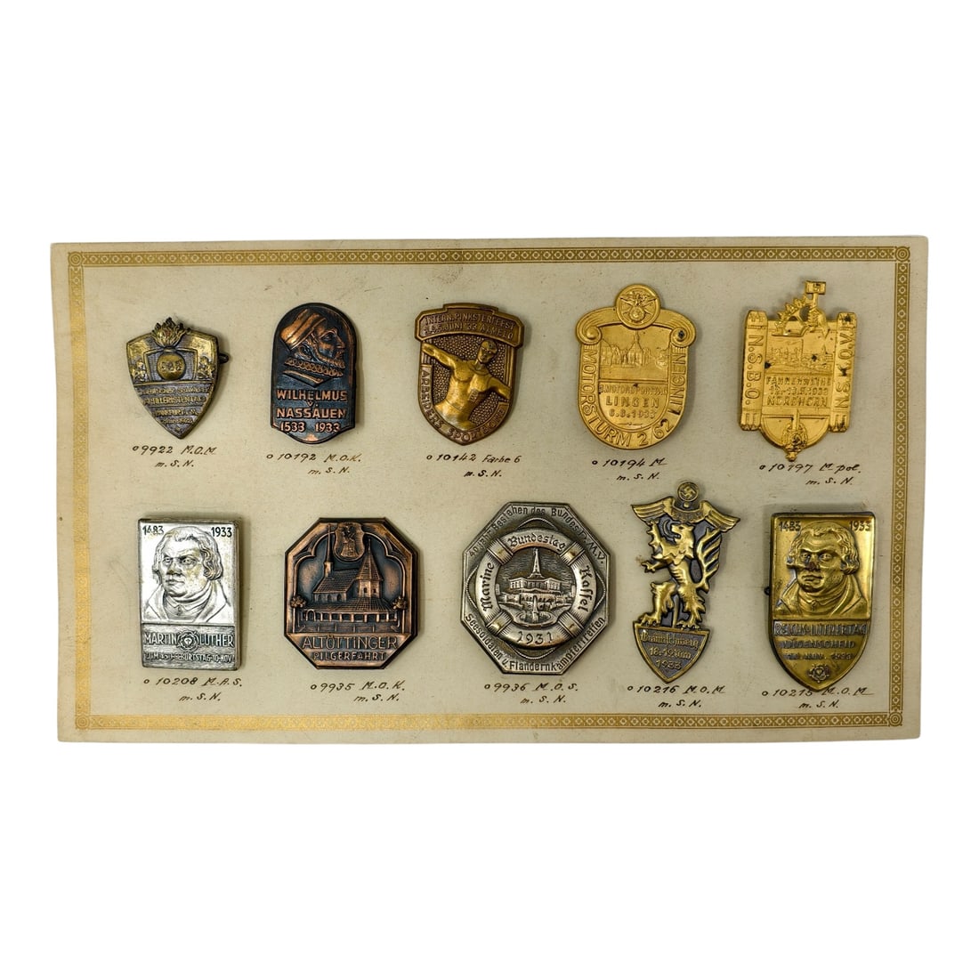 Third Reich Nazi Era Tinnie Set of Salesman Card: Original Third Reich era German display board featuring a collection of 1930s-era commemorative badges (tinnies), neatly mounted and identified with catalog-style numbers.The board presents a diverse