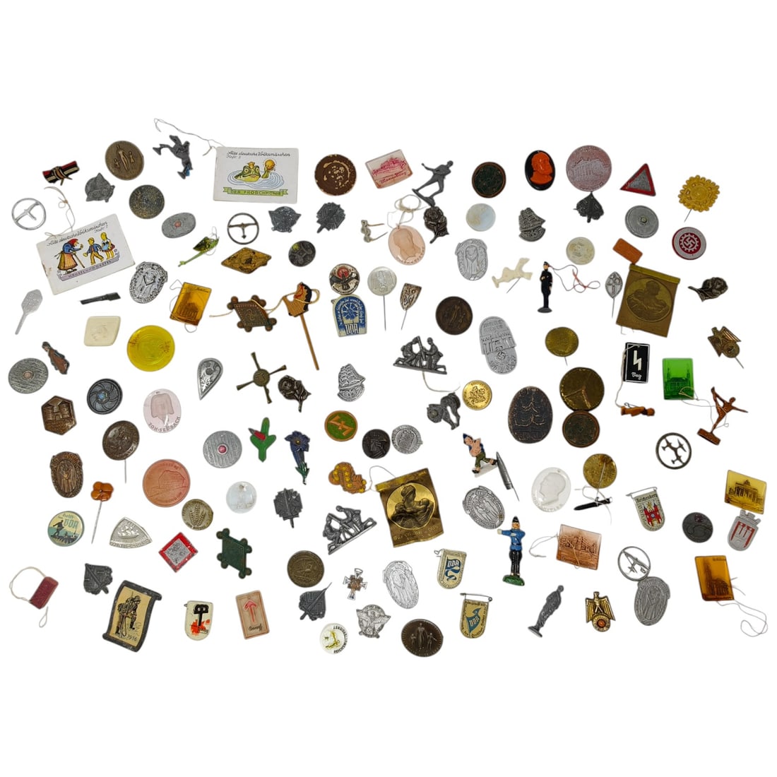 Mixed Lot of German WWII-Era WHW and Other Badges, Tinnies, Stickpins, and Ephemera: A large mixed lot of small collar and lapel badges, tinnies, stickpins, and paper tags, predominantly German WHW (Winterhilfswerk) charity badges from the WWII era, along with various other pins, meda