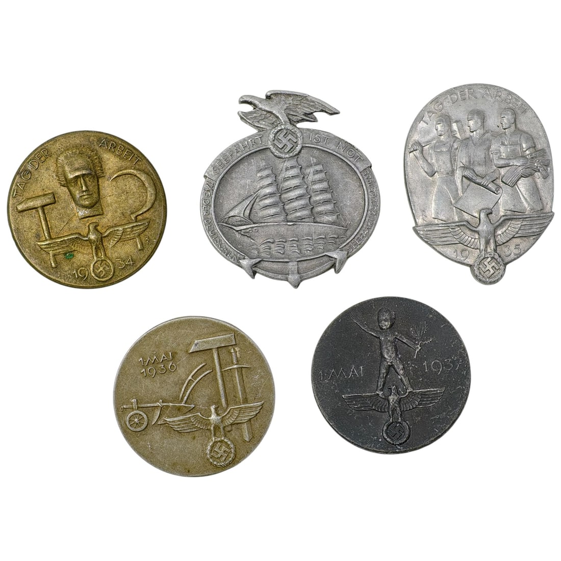 Third Reich Nazi Set of Tinnie Badges: A set of commemorative tinnie badges issued for May Day / Tag der Arbeit celebrations, dated 1934, 1935, 1936, and 1937. Designs include a stylized worker's head with winged wheel, a sailing ship with