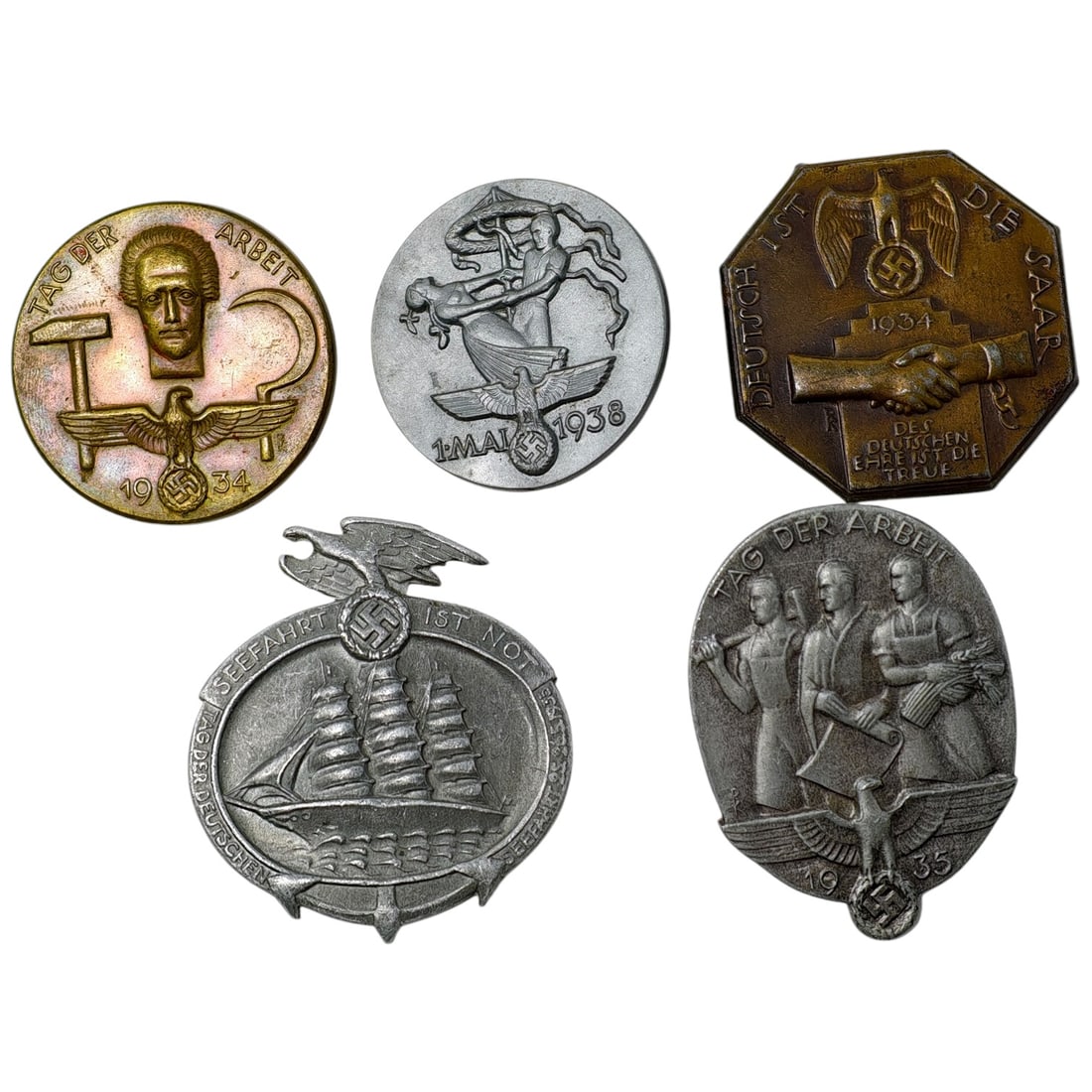 Third Reich Nazi Set of Tinnie Badges: A set of Third Reich period tinnie badges (Tinnies), commemorating events including Tag der Arbeit (Labor Day) 1934 and 1935, 1. Mai 1938, the Saarland reunification of 1934, and a Seefahrt ist Not