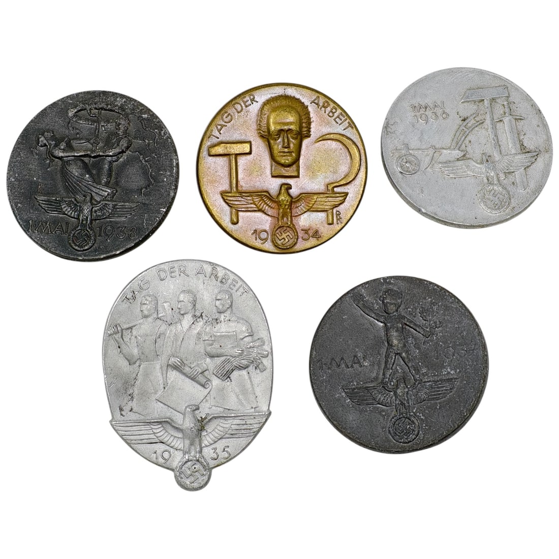 Nazi Third Reich Tinnie Event Badges: A set of commemorative tinnie badges issued for the National Socialist 'Tag der Arbeit' (Labour Day) celebrations, dated 1933, 1934, 1935, and 1936. Designs include stylized worker figures, an eagle