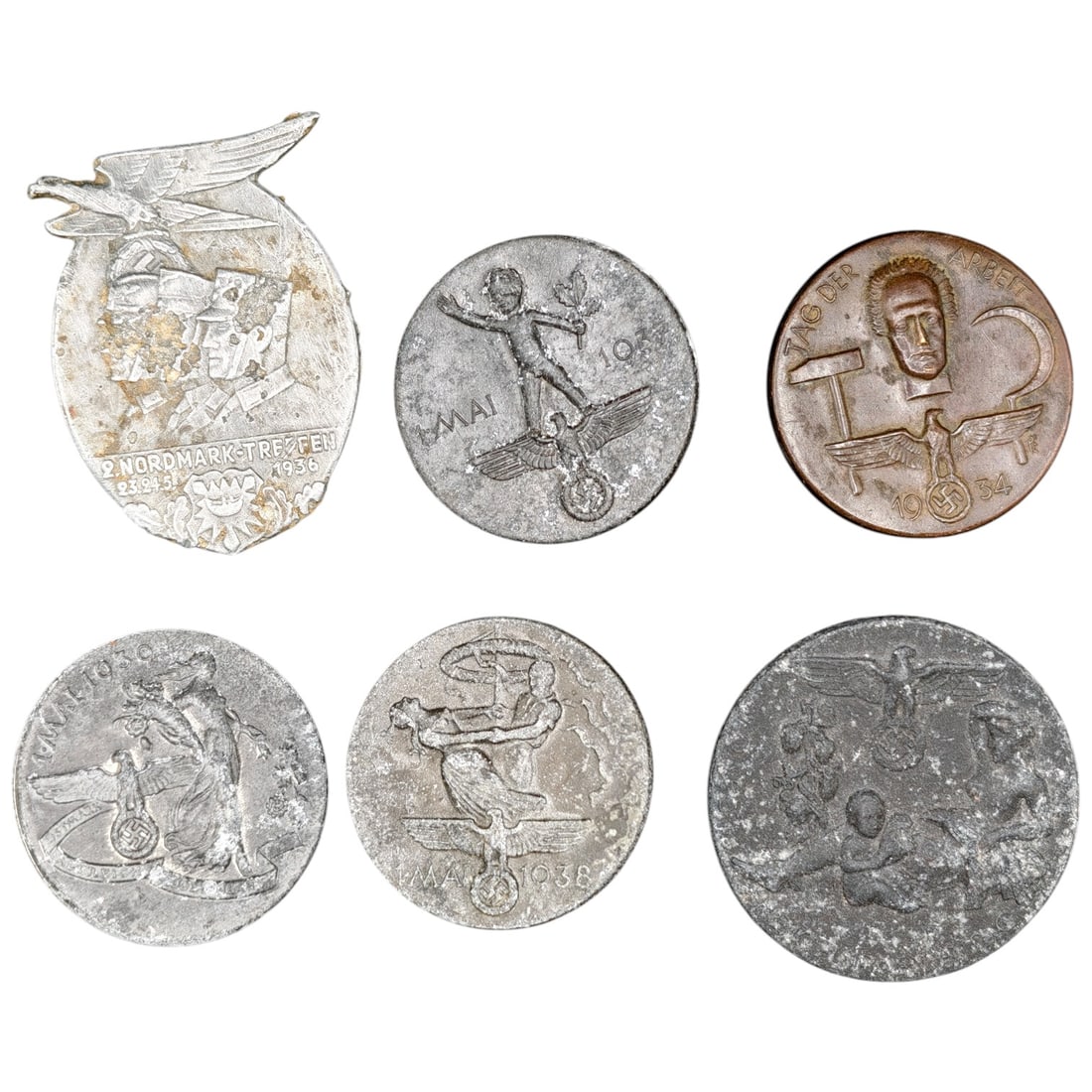 Third Reich Nazi Set of Tinnie Badges: A lot of tinnie badges commemorating various Third Reich era events and rallies, including a 'Nordmark-Treffen 1936' badge, a 'Tag der Arbeit' (May Day) 1934 example in what appears to be