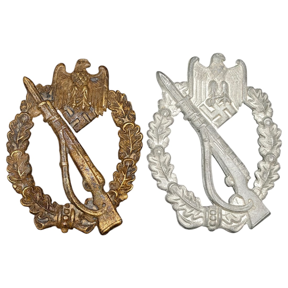 Third Reich Nazi Infantry Assault Badge Set: Two Infantry Assault Badges (Infanterie-Sturmabzeichen), one in what appears to be a bronze finish and one in what appears to be a silver finish, each depicting an eagle clutching a swastika above a
