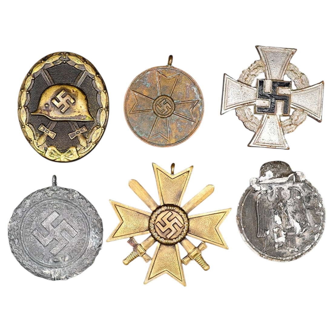 German WWII Third Reich Medal Group - War Merit Cross, Wound Badge, Long Service Cross, and: A grouping of Third Reich era medals and badges including a Wound Badge in a black finish with steel helmet and swastika, a War Merit Cross, a commemorative medal in what appears to be bronze of the S