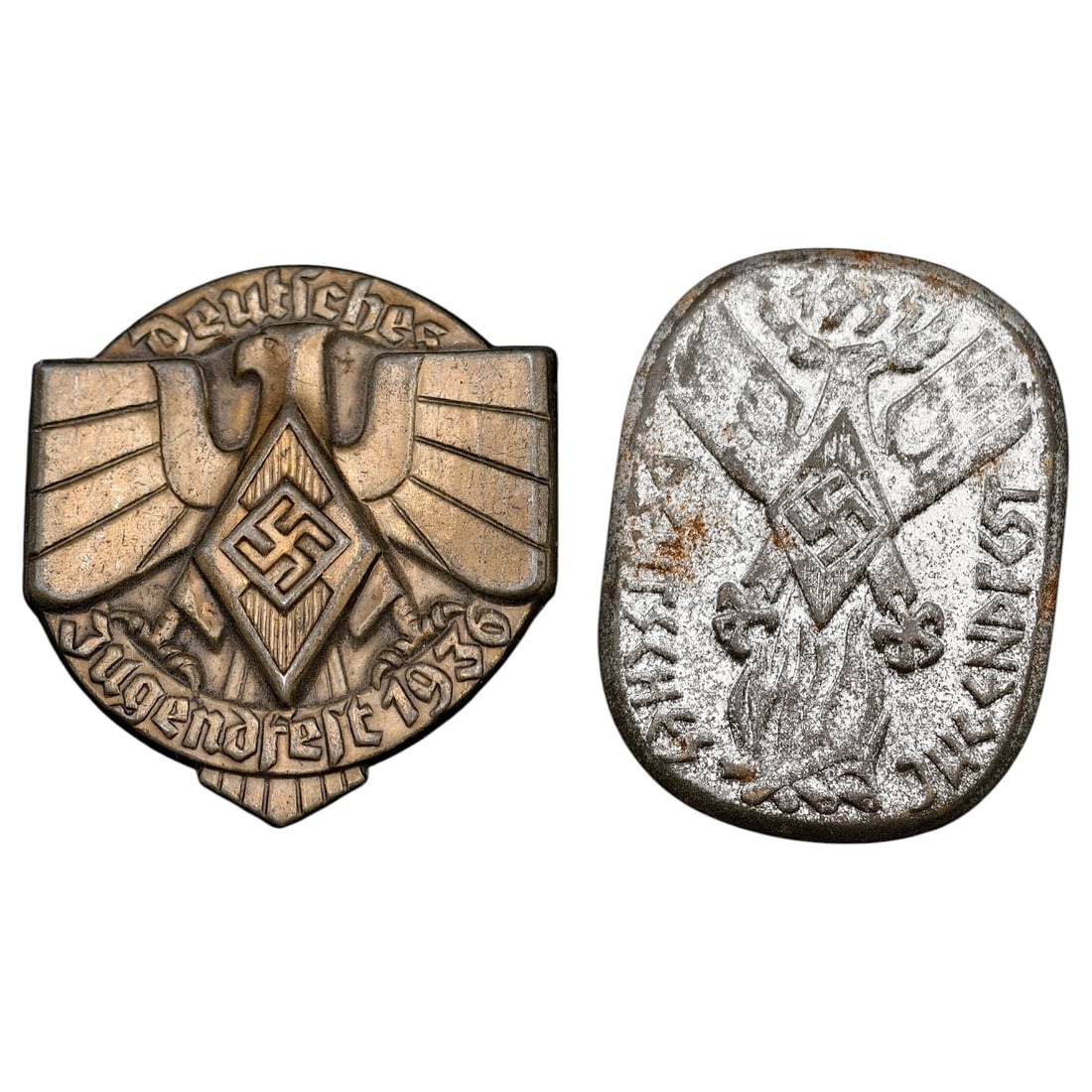 Third Reich Deutsches Jugendfest 1936 Tinnie Badge: A set of pressed metal tinnie badges. The first is a shield-shaped badge depicting the Hitler Youth eagle over a diamond swastika, inscribed "Deutsches Jugendfest 1936" in bronze-toned finish. The sec