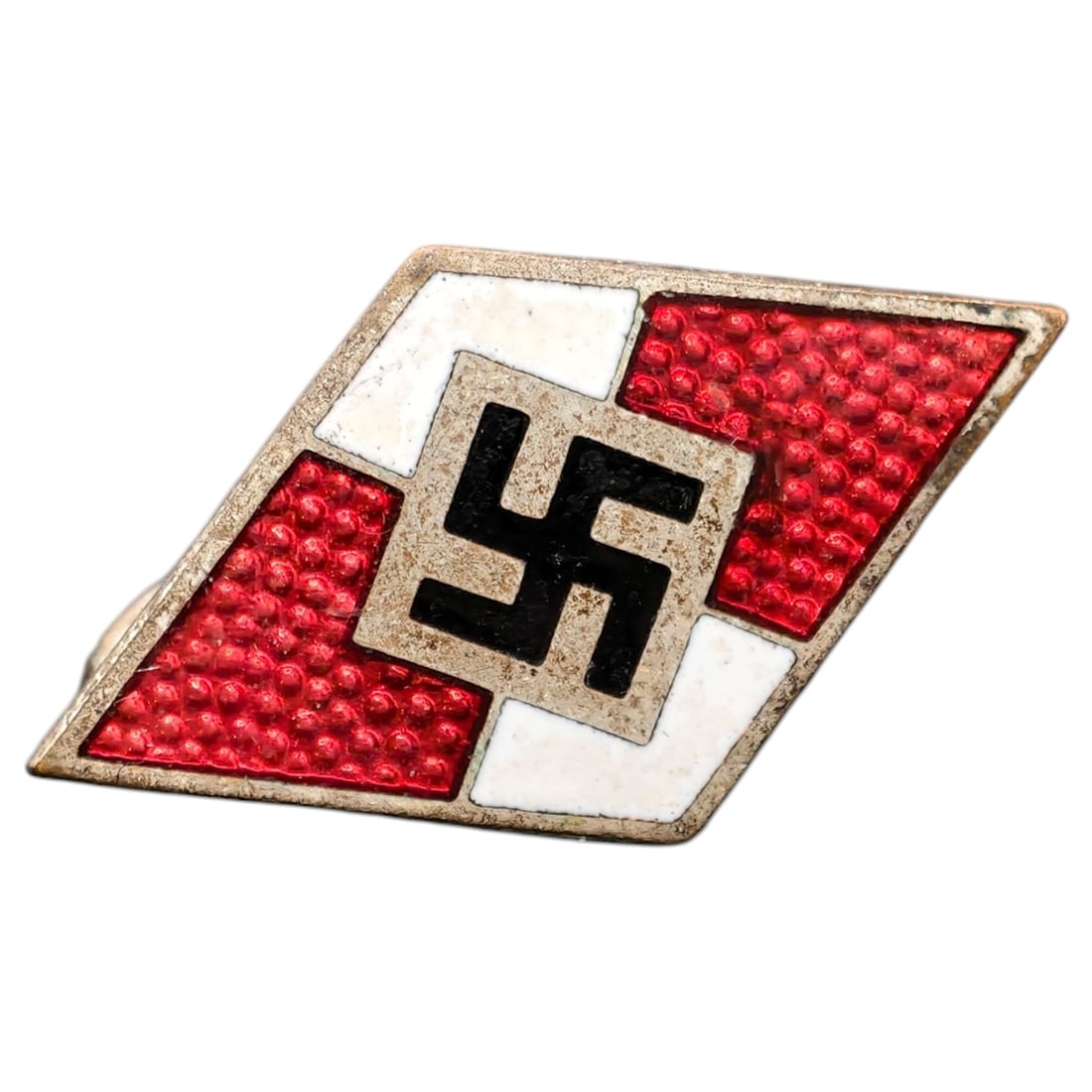 Hitler Youth Membership Badge: A diamond-shaped enamel membership badge featuring a central black swastika on a white field, flanked by red enamel quadrants with pebbled texture, set within a metal frame in what appears to be nicke