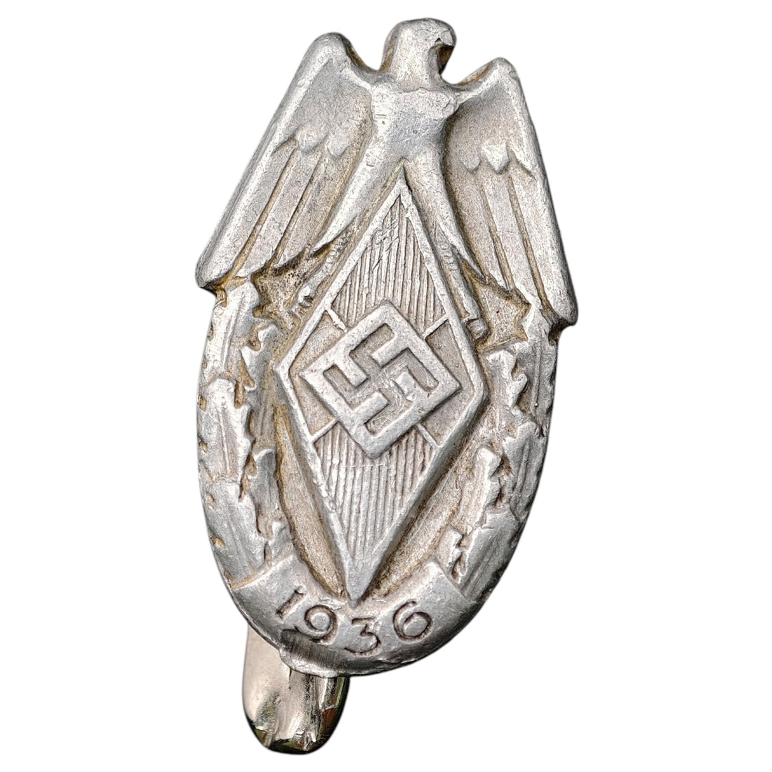 Hitler Youth 1936 Pin Badge: A stamped metal tinnie/pin badge featuring an eagle above a diamond-shaped shield with a central swastika motif and the date '1936' below. No maker markings are visible in the photos provided.