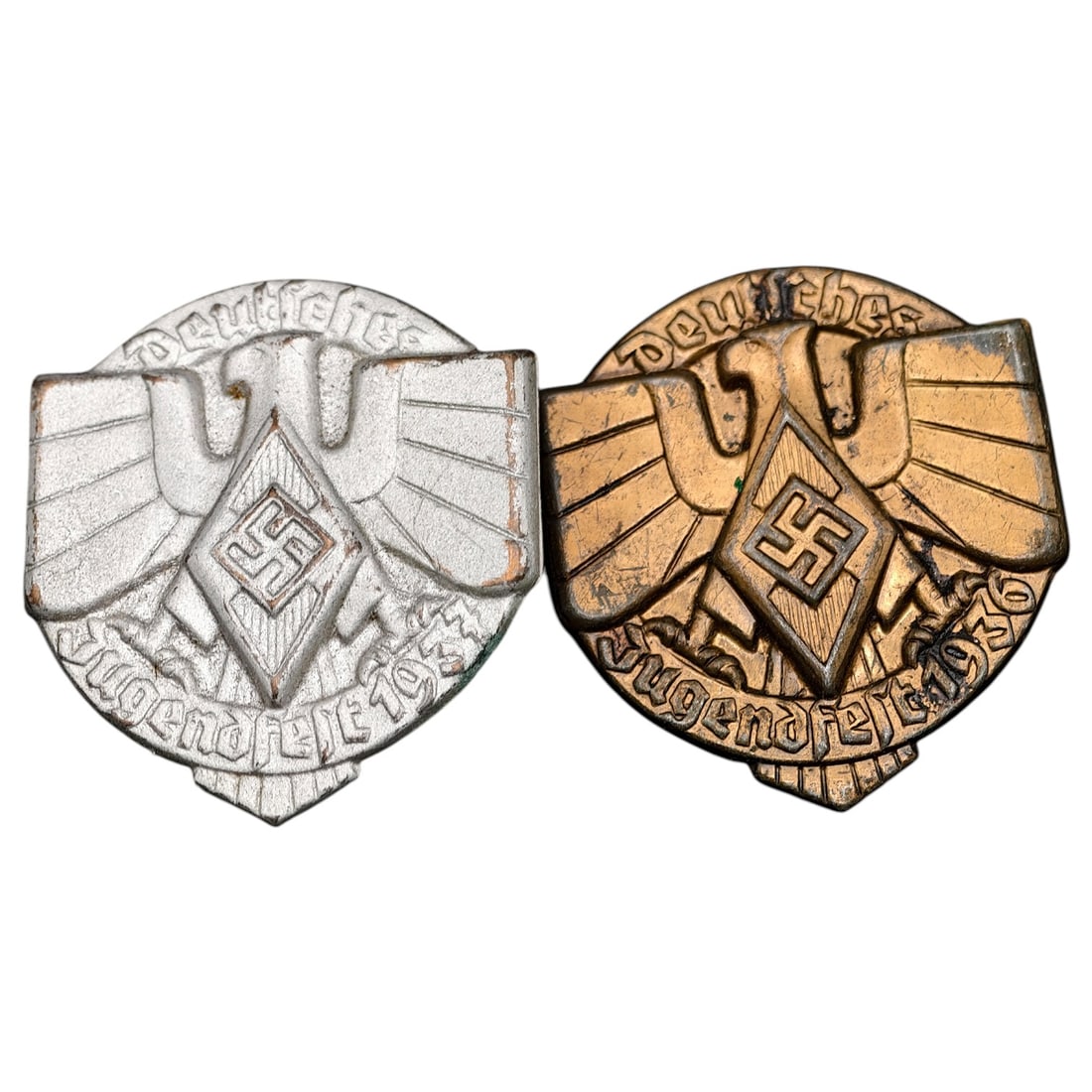 German WWII Hitler Youth Jugendfest 1936 and 1937 Badges (Pair): Pair of stamped metal membership badges (tinnies) commemorating the annual Hitler Youth 'Deutsches Jugendfest' events of 1936 and 1937. Each depicts a stylized eagle with outstretched wings above a di