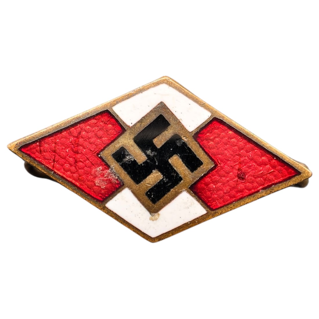 Hitler Youth Membership Badge: Diamond-shaped membership badge with red and white enamel sections surrounding a central swastika on a field appearing to be silver-toned.