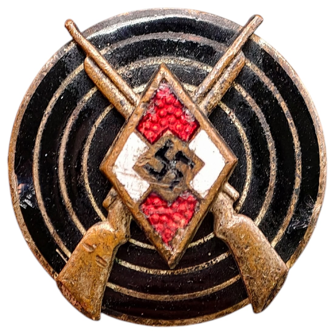 Hitler Youth Shooting Proficiency Badge: A tinnie-style badge featuring crossed rifles over a black target design, centered by an enameled red-white HJ diamond with black swastika. The reverse retains maker's RZM logo and code stamp partiall