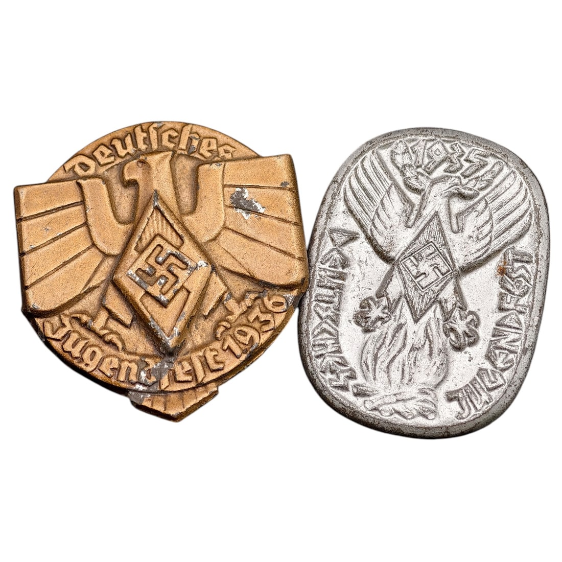 Third Reich Tinnie Pin Set - Deutsches Jugendfest 1936 and Similar Event Badge: Two pressed-metal commemorative tinnies (rally/event badges) for the Deutsches Jugendfest, one dated 1936 with 'Deutsches Jugendfest 1936' lettering around a stylized eagle and diamond-shaped swastika