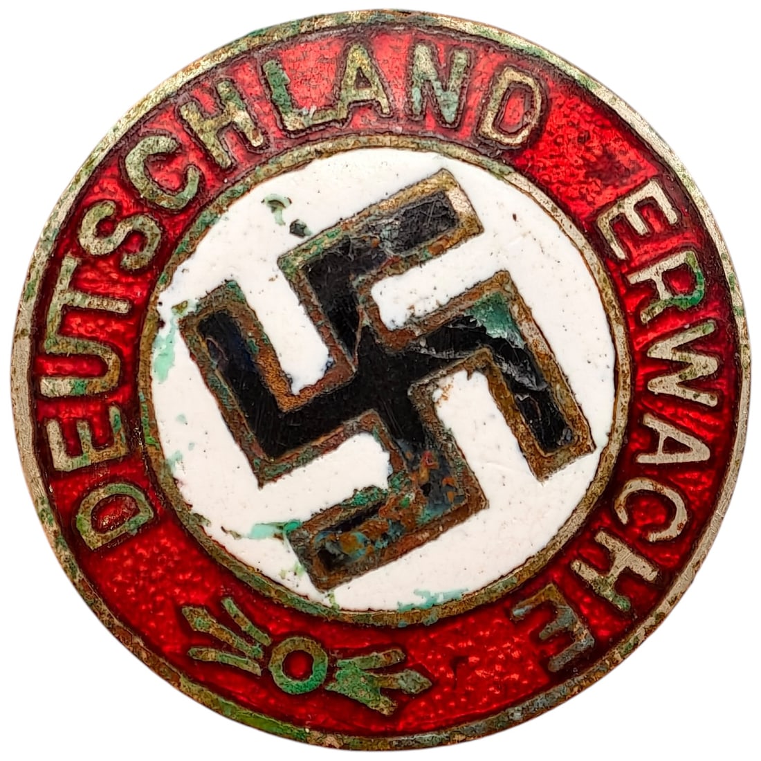 Early NSDAP Slogan Badge Deutschland Erwache: Round enameled tinnie-style badge with red enamel border reading 'DEUTSCHLAND ERWACHE' (Germany Awaken) surrounding a central black swastika on a white enamel field. Reverse retains a partially