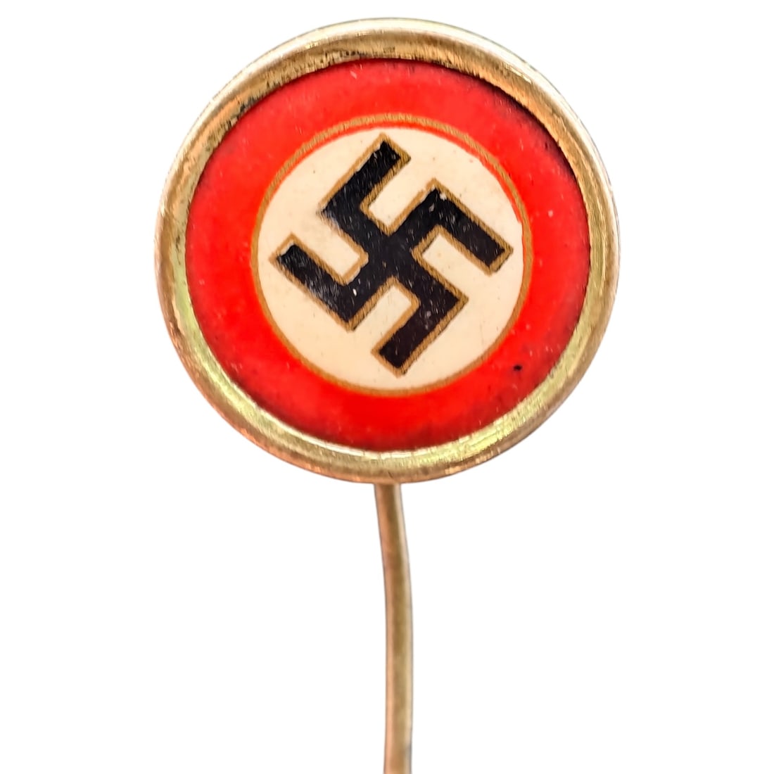 Early NSDAP Celluloid Pin: A round enamel stickpin featuring a black mobile swastika on white ground, encircled by a red enamel border and metal in what appears to be brass-toned rim. The reverse shows a plain metal disc. No