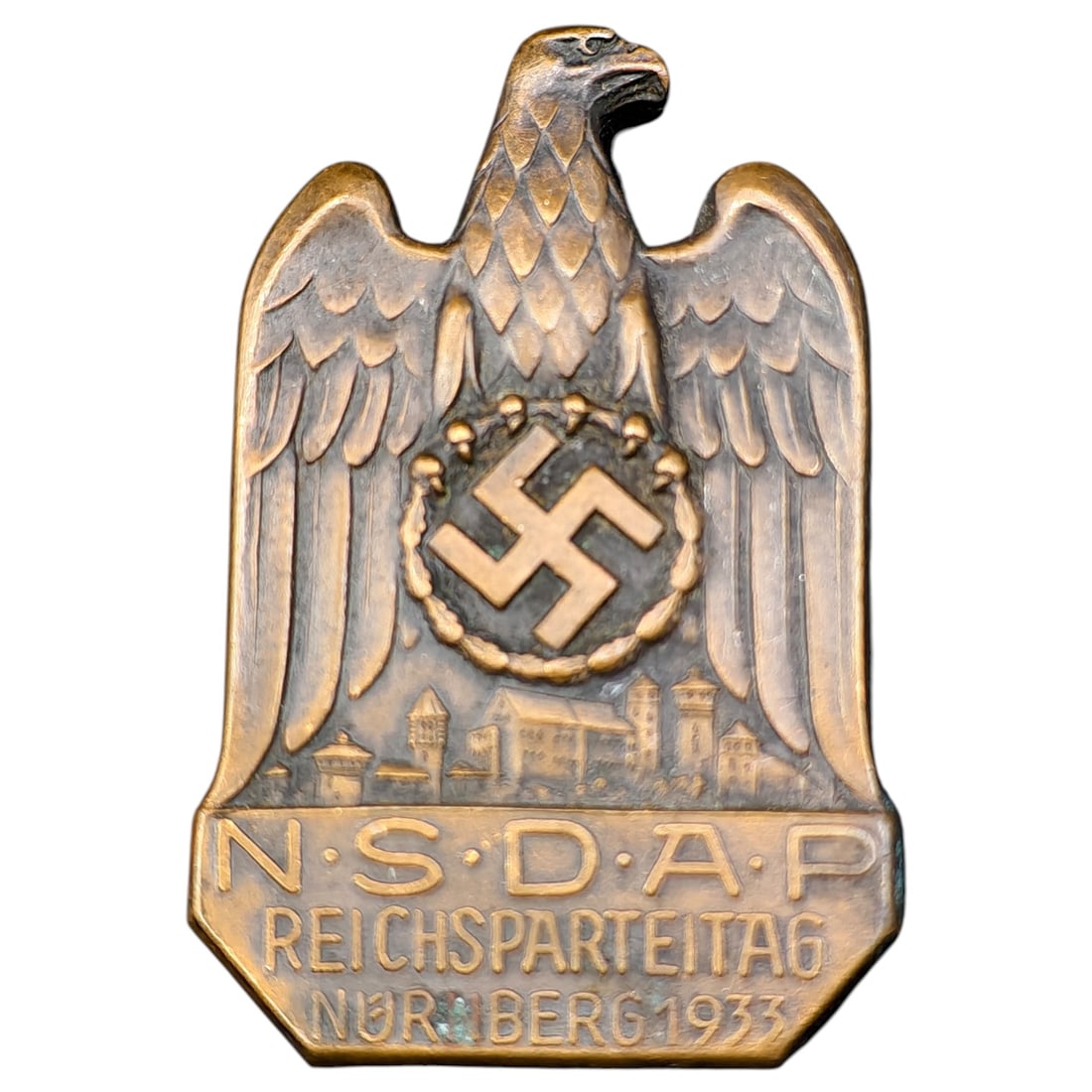 German WWII Reichsparteitag NSDAP 1933 Badge: A pressed metal commemorative badge (tinnie) for the 1933 NSDAP Reichsparteitag rally held in Nuremberg. The badge depicts an eagle with wings spread, a wreathed swastika roundel on its breast, and a