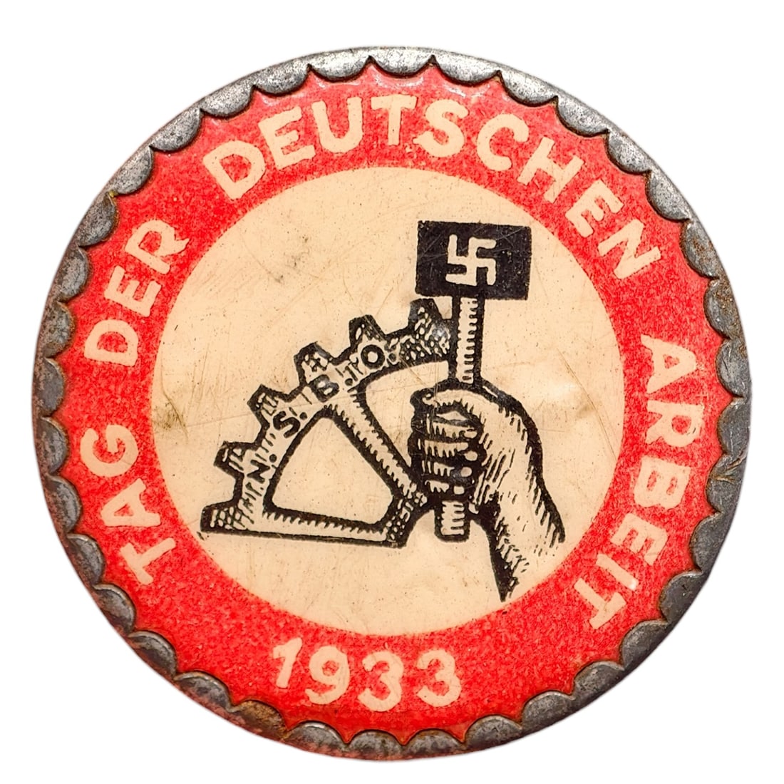 German 1933 'Tag der Deutschen Arbeit' Tinnie Badge: A tin badge commemorating the National Day of German Labor, 1933, with red enamel-painted field and raised inscription 'TAG DER DEUTSCHEN ARBEIT 1933' around the rim. The center depicts a hand grippin