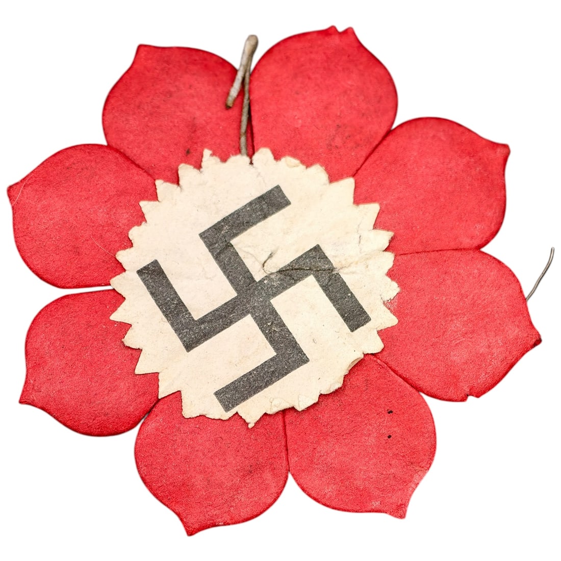 Early NSDAP Paper Flower Pin Badge: A red paper flower badge with eight petals, centered with a printed white disc bearing a black swastika, used as an early Party donation/collection-day pin. No maker markings are visible.