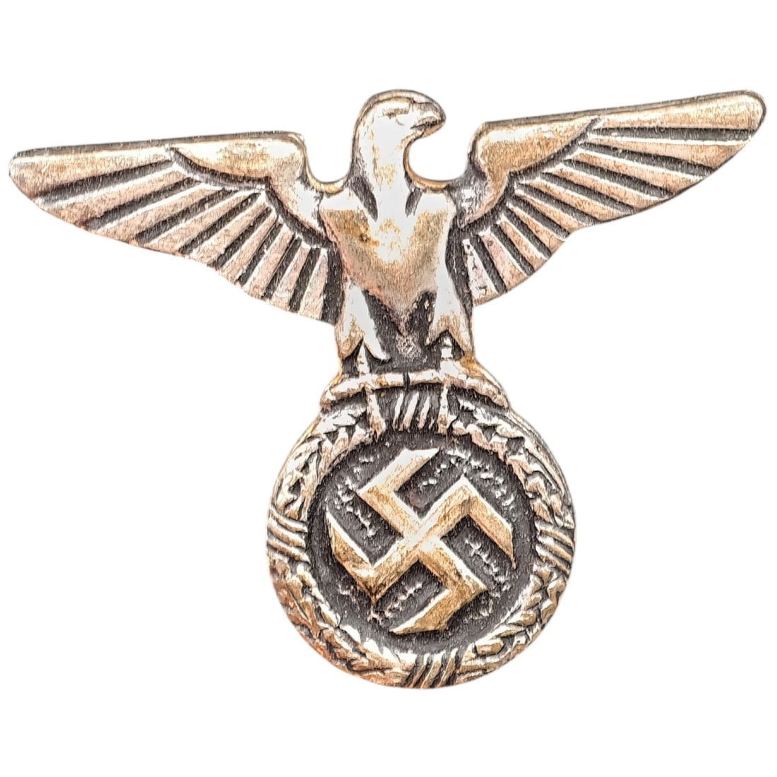 Third Reich Nazi NSDAP Eagle Stickpin: Small stick pin depicting an eagle with outstretched wings perched atop a wreathed swastika roundel, consistent with a political or party insignia badge. The reverse shows a maker stamp reading