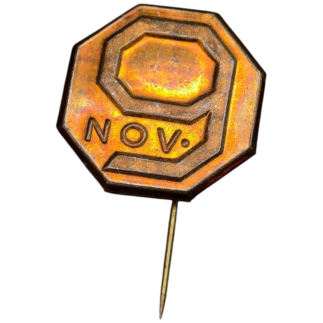 German 'Nov. 9' Commemorative Stickpin Badge: An octagonal stickpin badge with raised numeral '9' and the inscription 'NOV.' commemorating November 9th, likely associated with interwar German political commemorations. The obverse shows a finish
