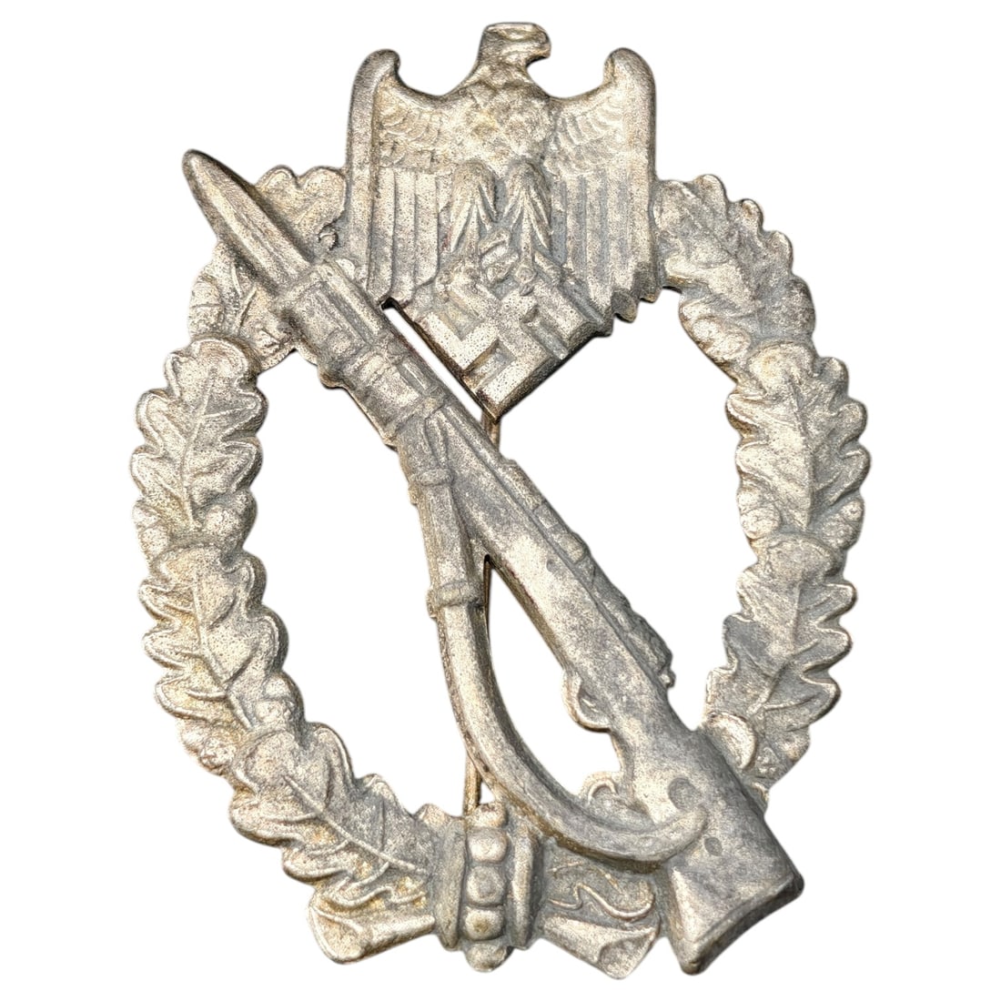 Third Reich Nazi Infantry Assault Badge: An Infanterie-Sturmabzeichen in what appears to be silver tone, featuring an eagle with mobile swastika above an oval wreath of oak leaves enclosing a crossed rifle (K98) and bayonet. Constructed of w