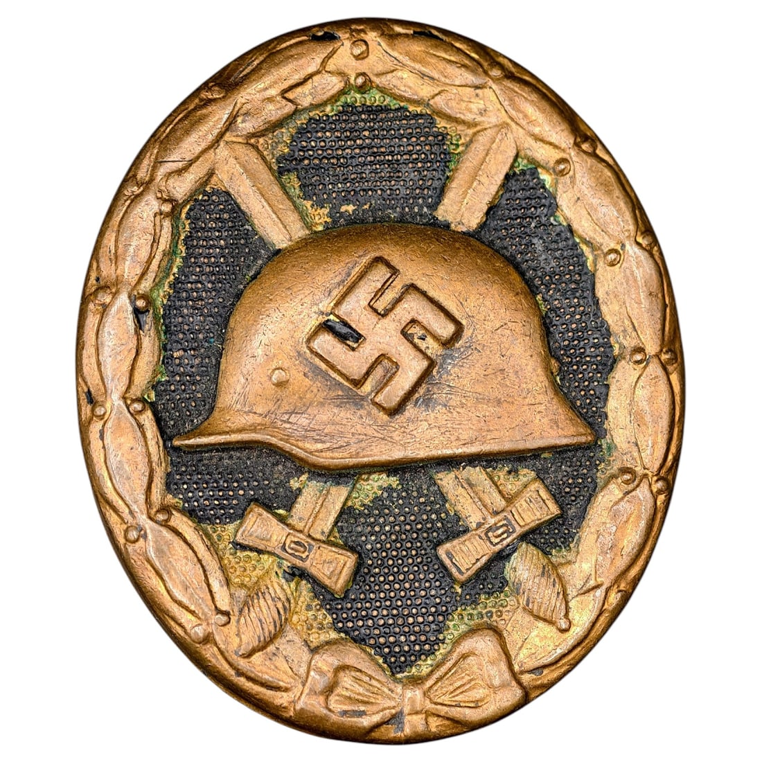 Wound Badge in Black – Third Reich Nazi Era Medal Badge: A Third Reich Wound Badge (Verwundetenabzeichen) in what appears to be black grade, depicting a steel helmet over a swastika, flanked by crossed swords, within a wreath border.