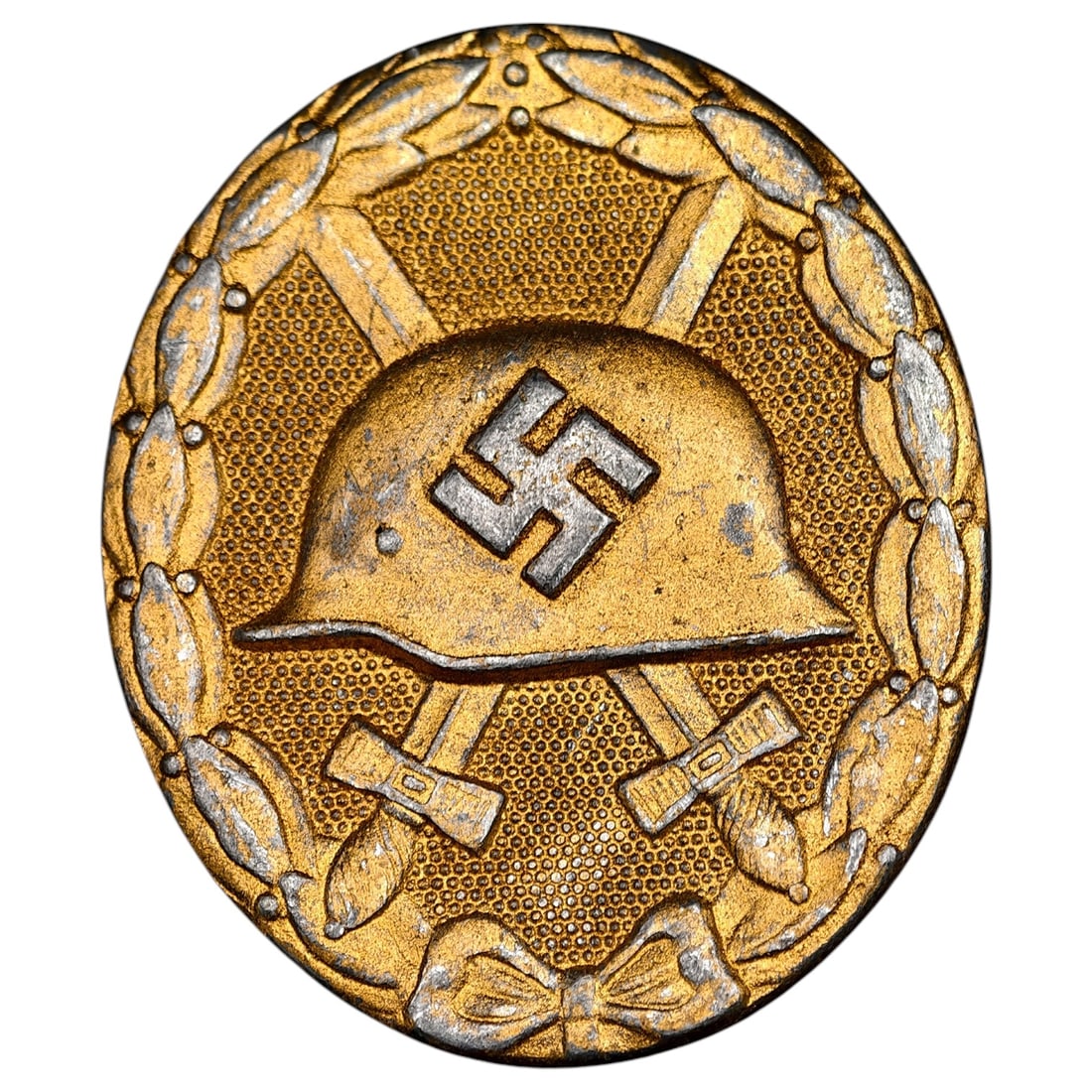 Third Reich Nazi Wound Badge in Gold: A Third Reich Wound Badge in gold class, oval form, depicting a stahlhelm over crossed swords within a laurel wreath. Textured stippled background typical of vossberg-style construction, gold-toned fi