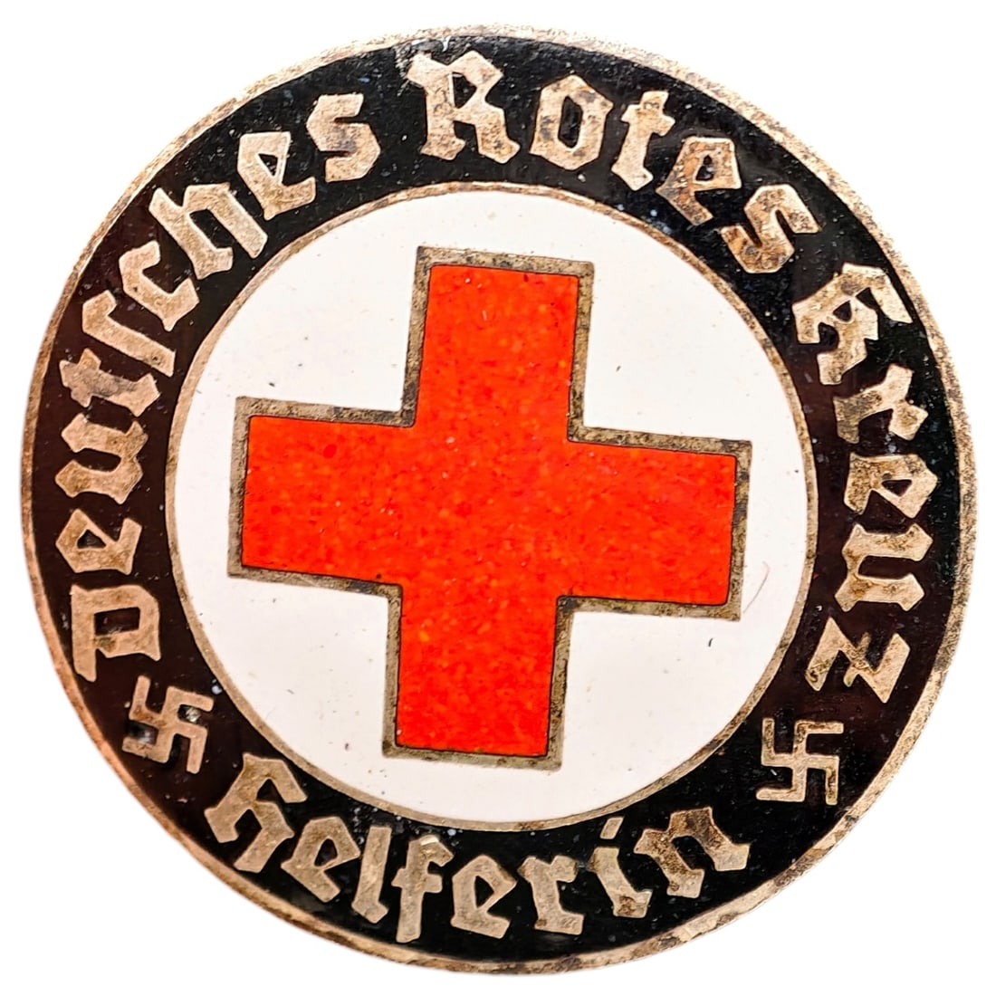 Third Reich Nazi Red Cross Badge: Enameled member badge for the Deutsches Rotes Kreuz (German Red Cross), inscribed "DEUTSCHES ROTES KREUZ HELFERIN" around a central red cross on white enamel field with black outer ring and gothic let