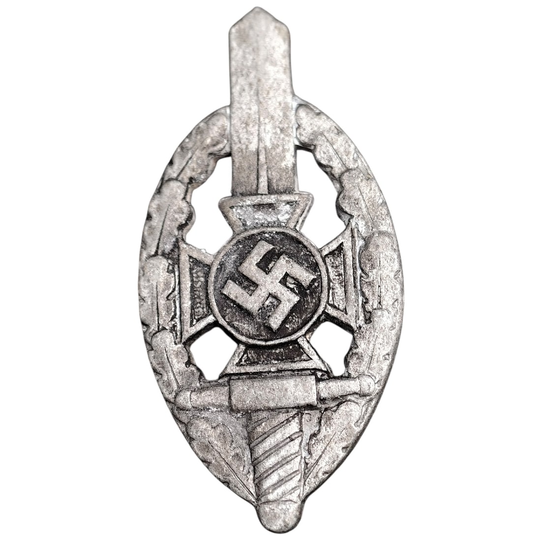 Third Reich Veterans Association Pin Badge: A miniature pin badge in the form of an oval wreath enclosing a sword, cross pattée, and mobile swastika roundel, likely worn by members of a Third Reich veterans' or ex-servicemen's association. Rev