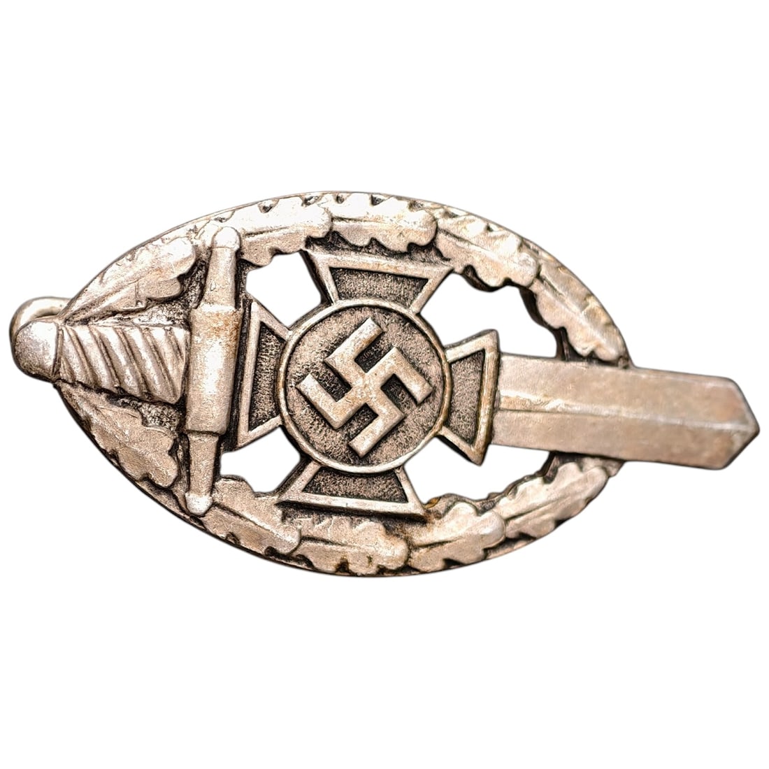 Third Reich Veterans Association Pin Badge: A miniature pin badge in the form of an oval wreath enclosing a sword, cross pattée, and mobile swastika roundel, likely worn by members of a Third Reich veterans' or ex-servicemen's association. Rev