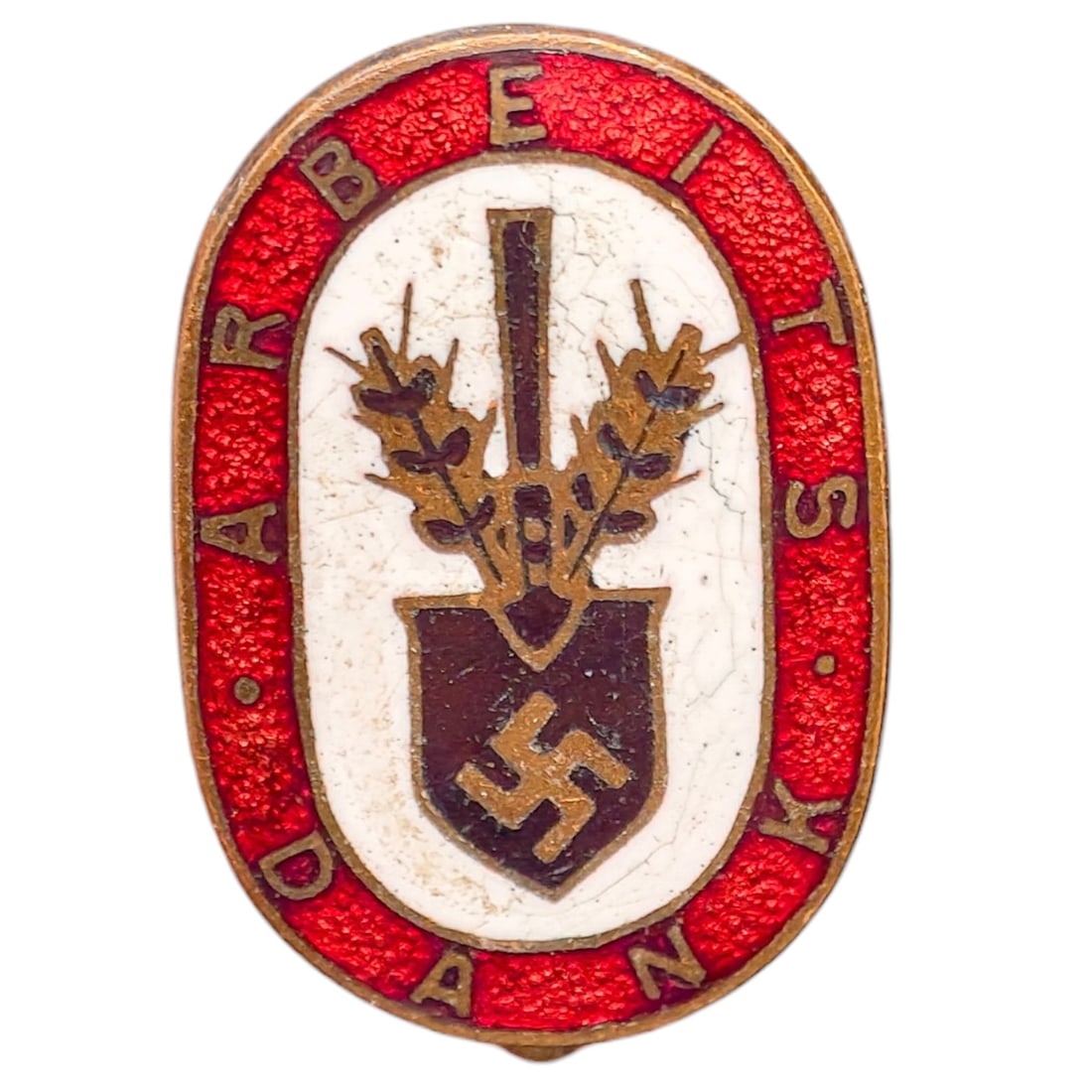 Third Reich Nazi RAD Arbeits Dank Badge: Enameled tinnie/donation badge with red oval border reading 'ARBEITS DANK' surrounding a white field with a crossed spade and wheat sheaf motif over a shield bearing a swastika.
