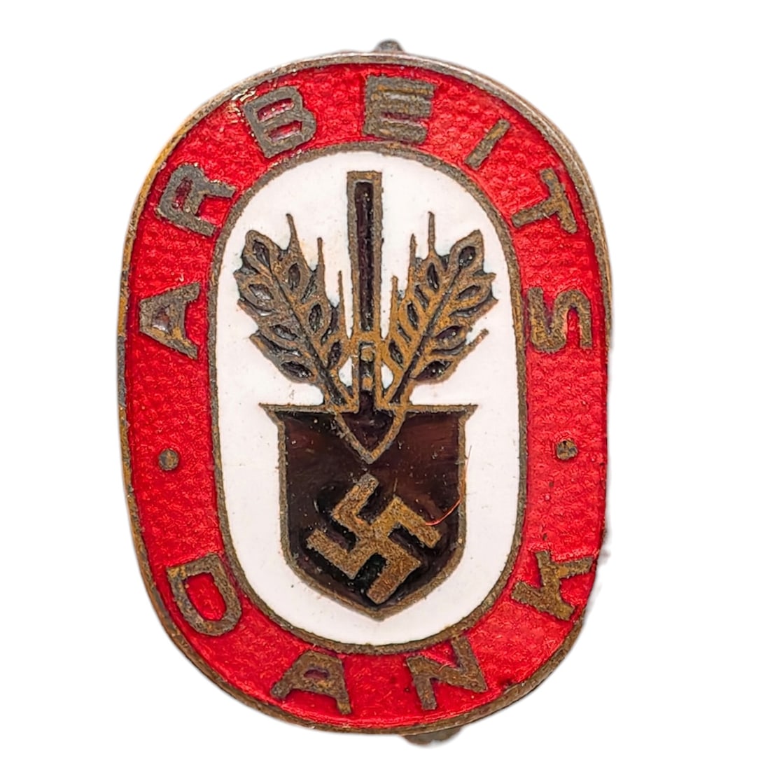 Third Reich Nazi RAD Arbeits Dank Badge: Enameled tinnie/donation badge with red oval border reading 'ARBEITS DANK' surrounding a white field with a crossed spade and wheat sheaf motif over a shield bearing a swastika.