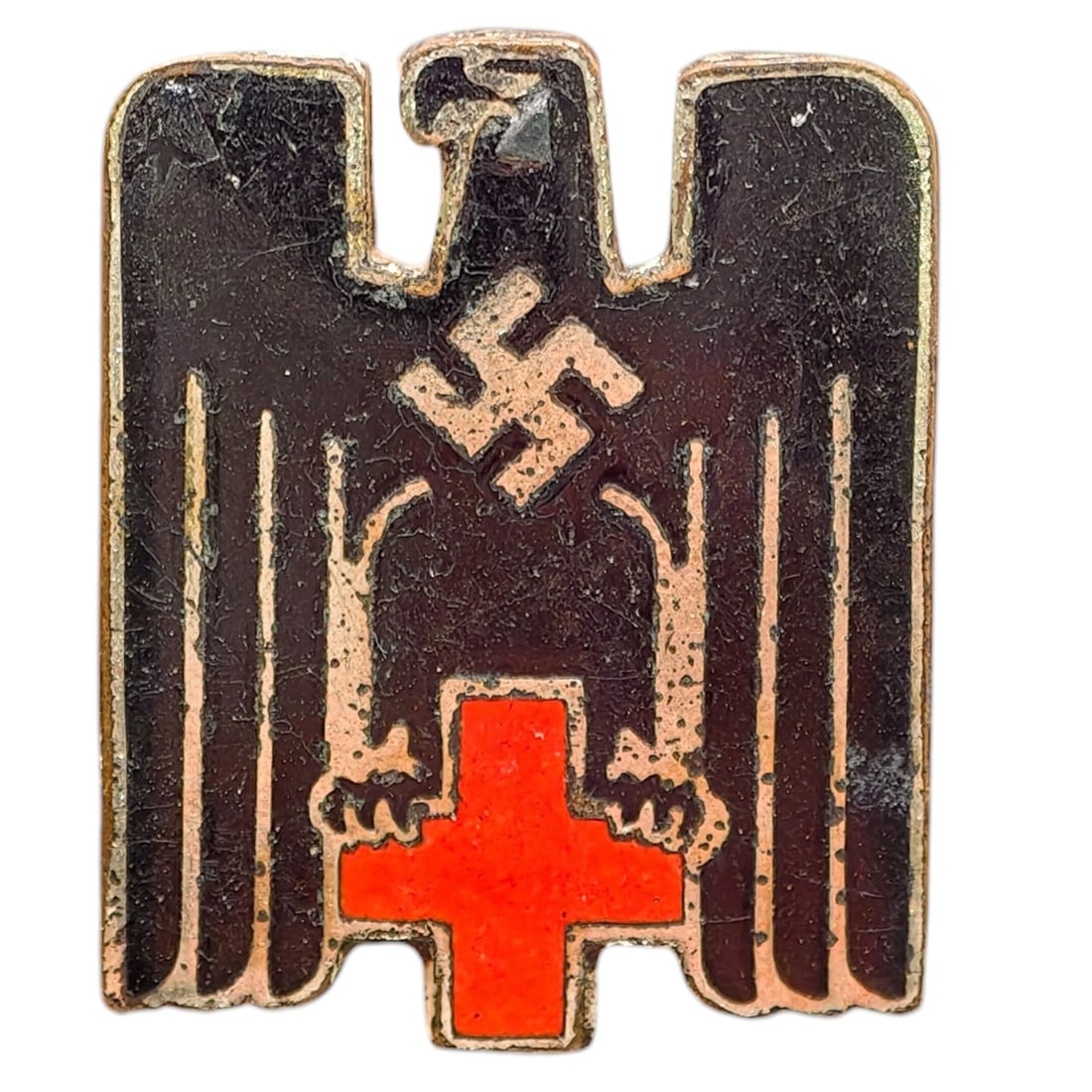 Third Reich Nazi Red Cross Pin: A small enameled pin badge in the form of a stylized eagle with swastika above a red enamel cross, worn by German Red Cross (DRK) members or supporters.