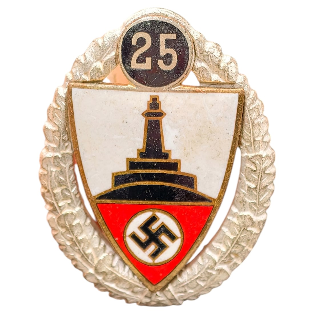 German WWII Veterans Association 25 Year Membership Badge: Enameled pin-back badge featuring a shield with the Kyffhäuser Monument on a white ground above a red field with a central swastika roundel, surmounted by a black '25' numeral disc, surrounded by an 