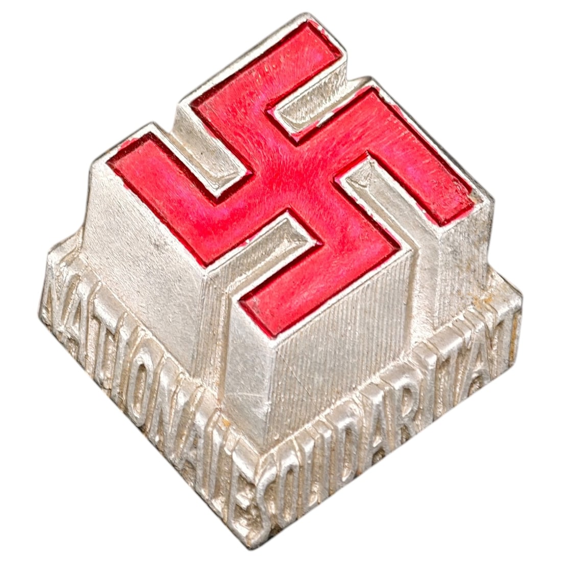 Austrian "Nationale Solidarität" Swastika Pin Badge: A pyramidal metal tinnie/pin badge with a red-enameled swastika on a base in what appears to be a silver tone, stepped, inscribed "NATIONAL SOLIDARITÄT" around the lower edge. This refers to the Aust