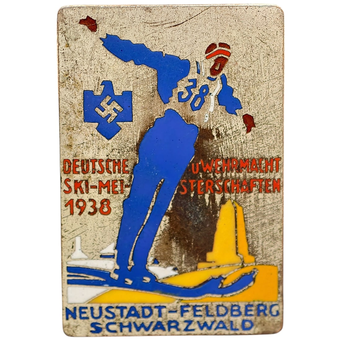 German 1938 Deutsche Wehrmacht Ski Championships Badge, Neustadt-Feldberg Schwarzwald: A tinnie/badge commemorating the 1938 Deutsche Wehrmacht Ski-Meisterschaften held at Neustadt-Feldberg in the Schwarzwald. Enameled in blue, red, and yellow on a body in what appears to be white metal