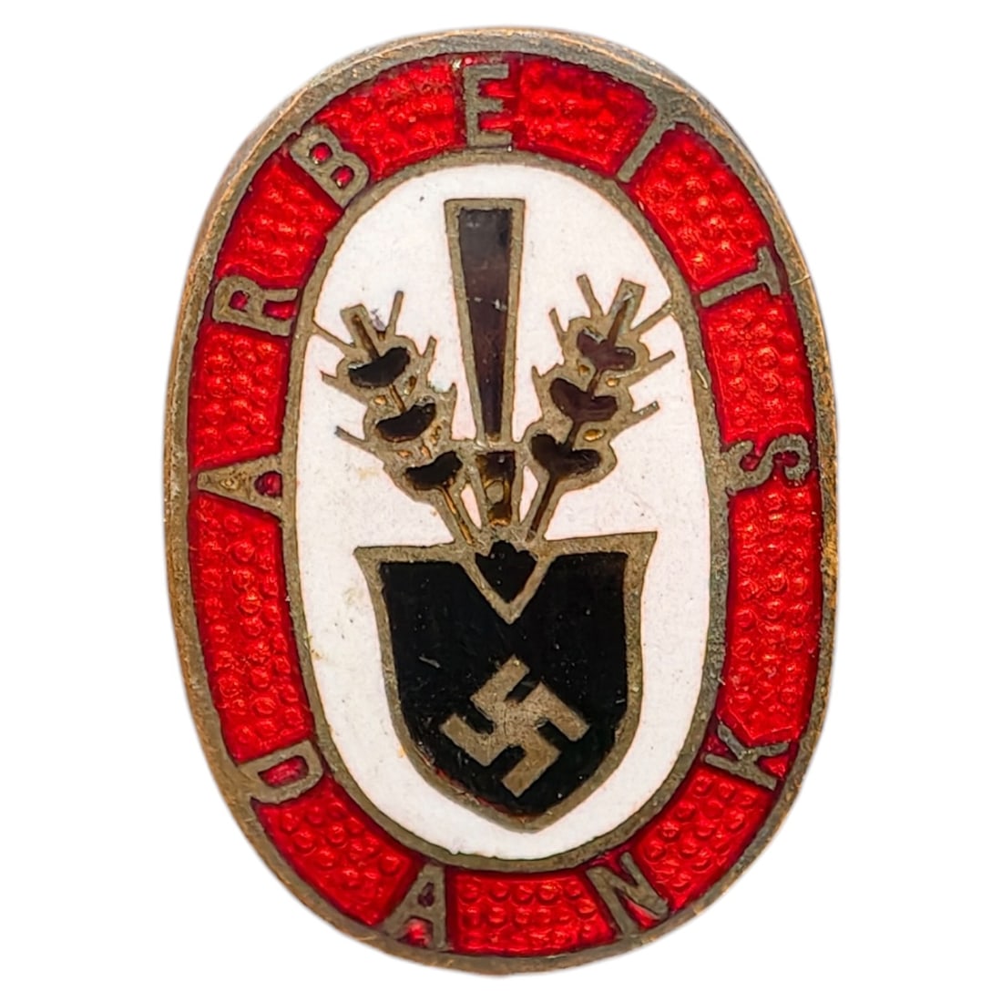 Third Reich Nazi RAD Arbeits Dank Badge: Enameled tinnie/donation badge with red oval border reading 'ARBEITS DANK' surrounding a white field with a crossed spade and wheat sheaf motif over a shield bearing a swastika.