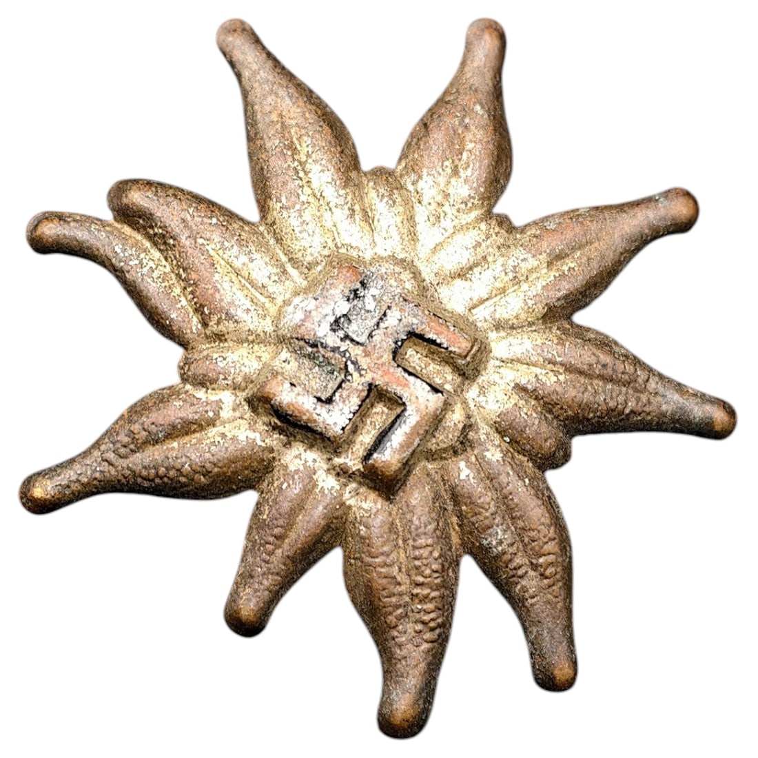 Third Reich Swastika Edelweiss Badge: A stamped metal Edelweiss badge with a central mobile swastika device, mounted for wear. The badge shows a gilt/bronze-toned finish believed to be applied over the base metal. No maker marks are visib