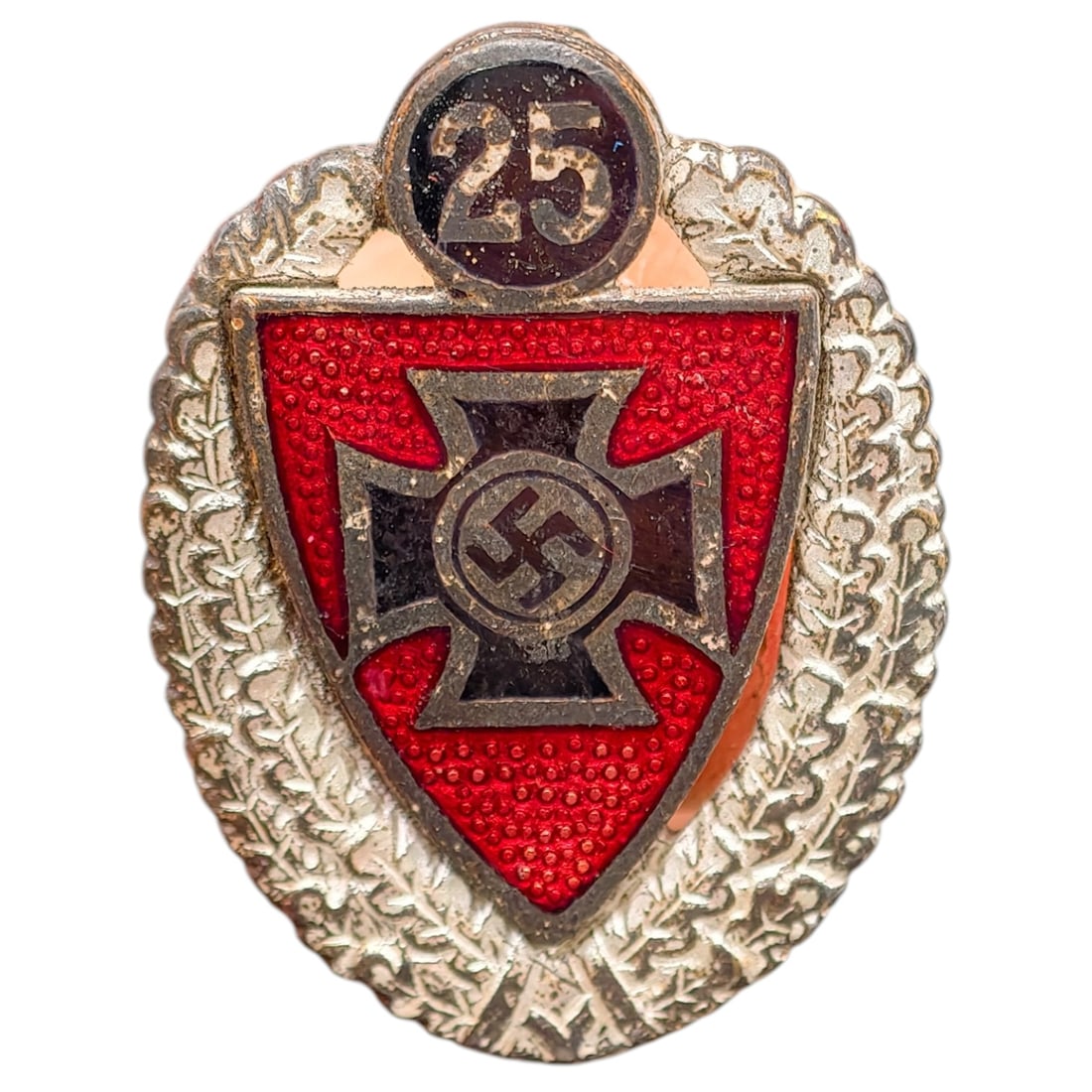 Third Reich Nazi Veterans Association 25 Year Badge: Silvered metal veterans' loyalty badge in the form of an oak leaf wreath surmounted by a '25' year tablet, enclosing a red-enameled shield with a black cross bearing a central swastika roundel. Revers
