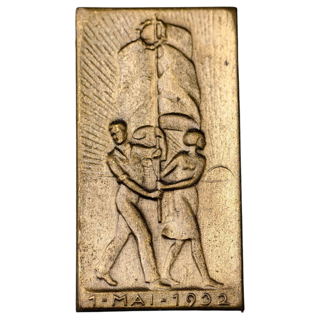 1932 May Day (1. Mai) Commemorative Badge, Rectangular Pin: A rectangular badge commemorating '1. Mai 1932' (May Day), depicting a male and female worker walking together beneath a large banner or flag mounted on a pole, with radiating sunburst lines behind th