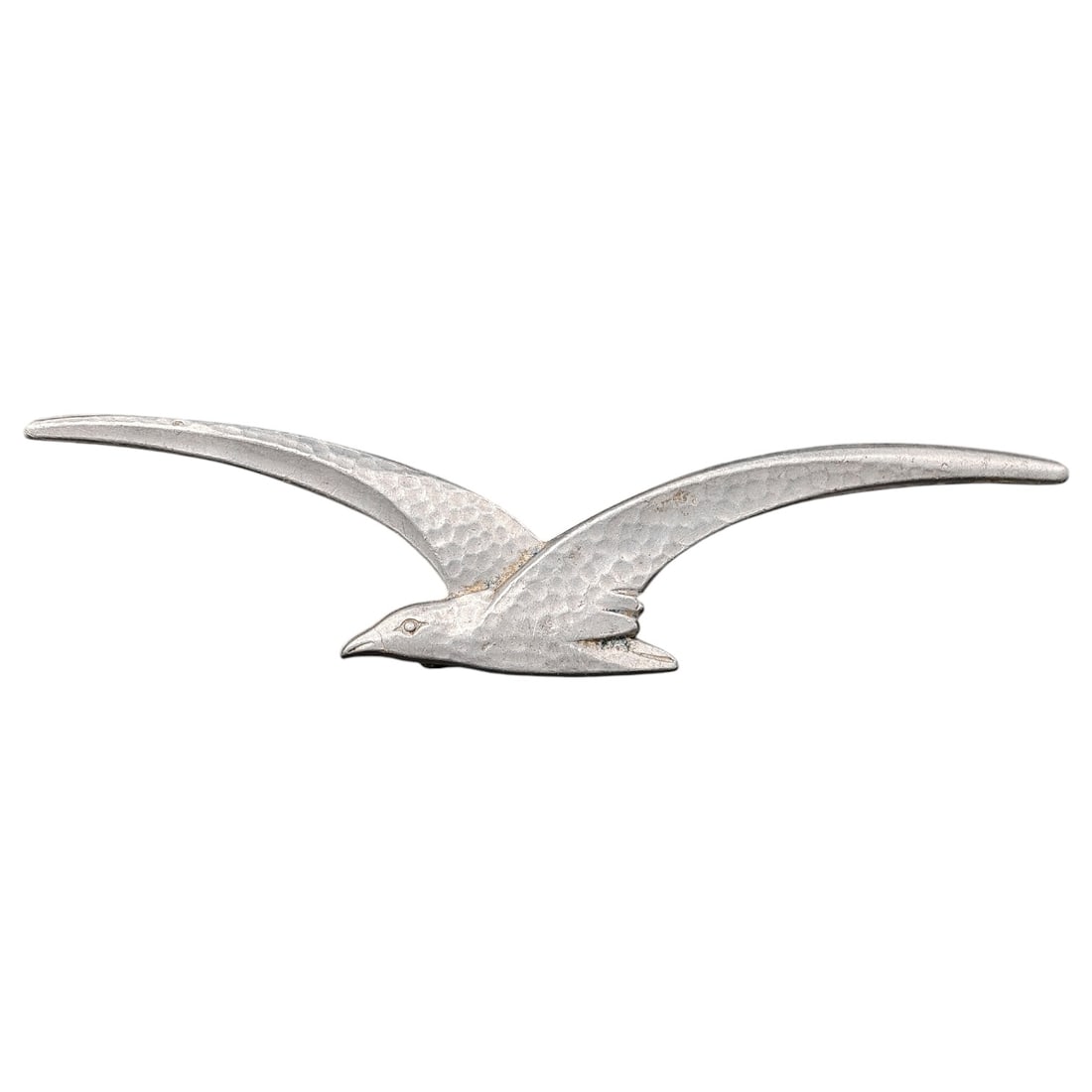 Stylized Seagull-Form Metal Brooch/Badge: A cast metal brooch or lapel badge in the form of a flying seagull with outstretched wings, featuring a hammered/textured surface finish and a silvered or painted metallic tone.