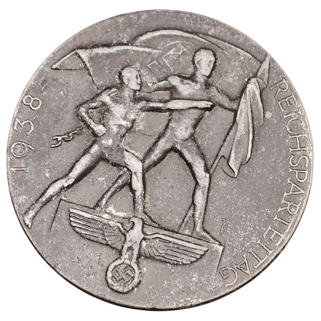 NSDAP Reichsparteitag 1938 Badge: Pin-back commemorative badge (tinnie) for the 1938 Reichsparteitag (Nazi Party Rally at Nuremberg), depicting two stylized male figures with flags standing over an eagle emblem, dated 1938 to left fie