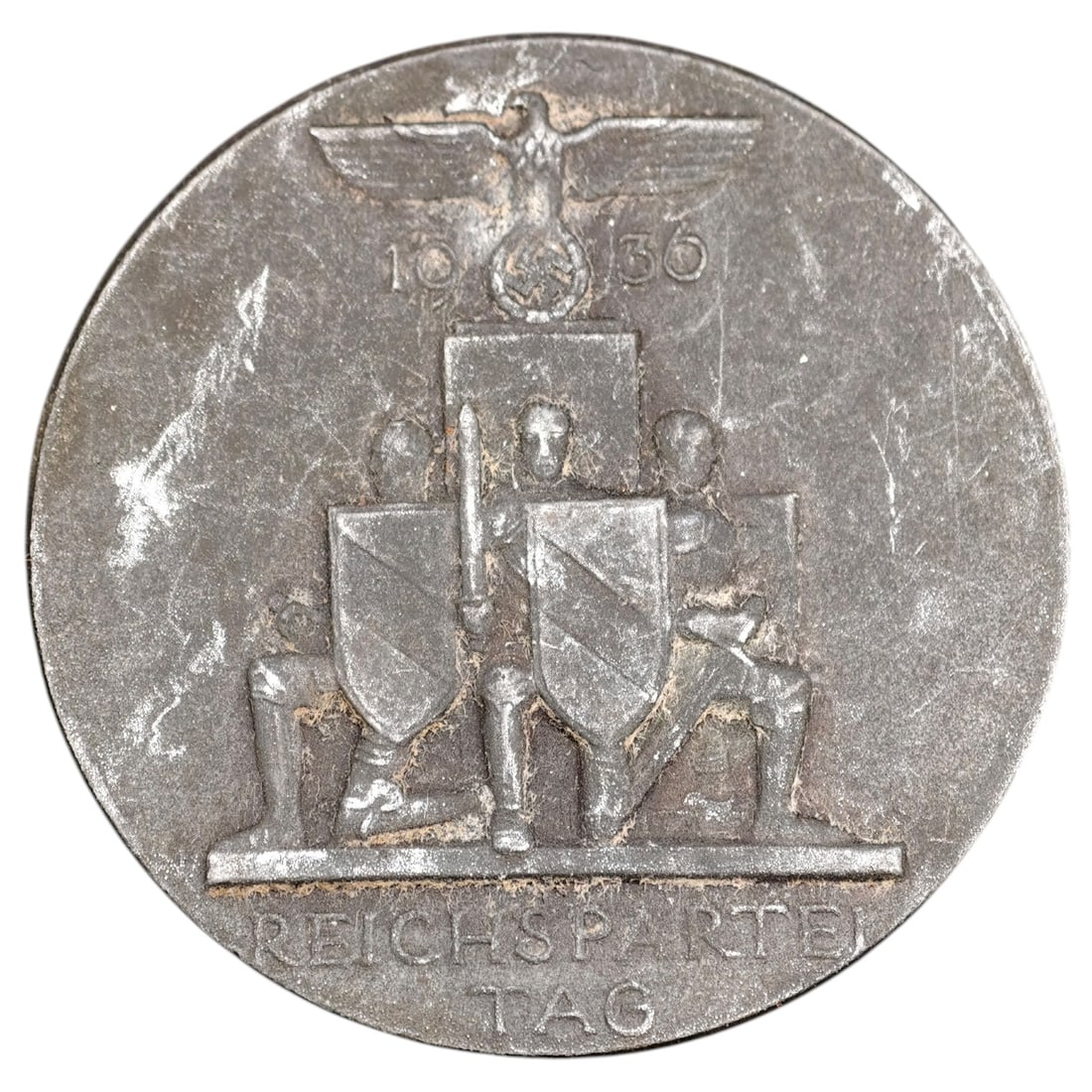 German WWII Nazi Reichsparteitag 1936 Badge: A commemorative tinnie badge for the 1936 Reichsparteitag (Nazi Party Rally at Nuremberg), depicting a Party eagle above the date "1936" and a set of kneeling figures holding shields and a sword, with
