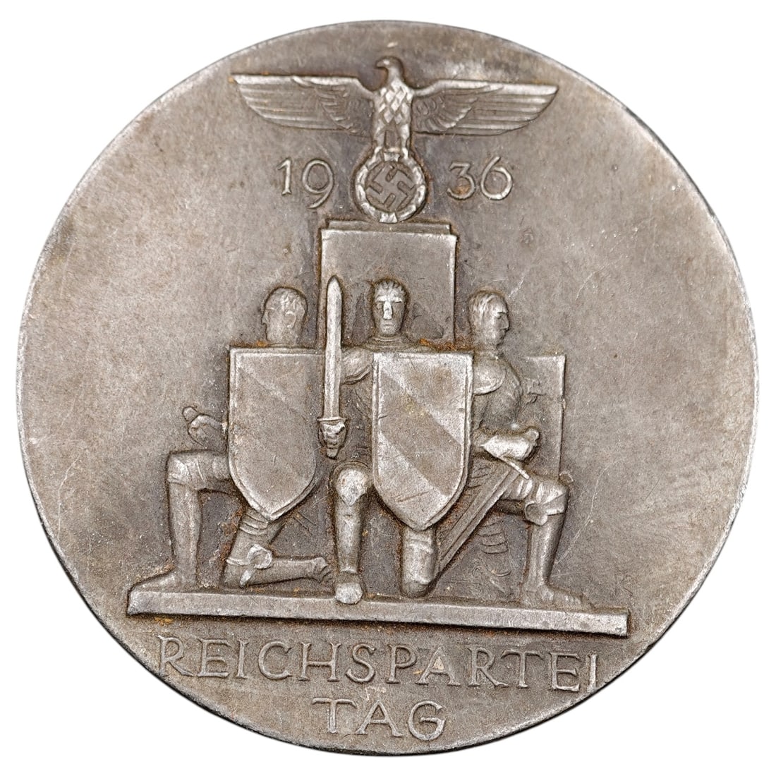 Third Reich Nazi Reichsparteitag 1936 Badge - Heavy Variant: A commemorative tinnie badge for the 1936 Reichsparteitag (Nazi Party Rally), featuring a Reichsadler with wreathed swastika above kneeling shield-bearing figures, with 'REICHSPARTEI TAG' and date '19
