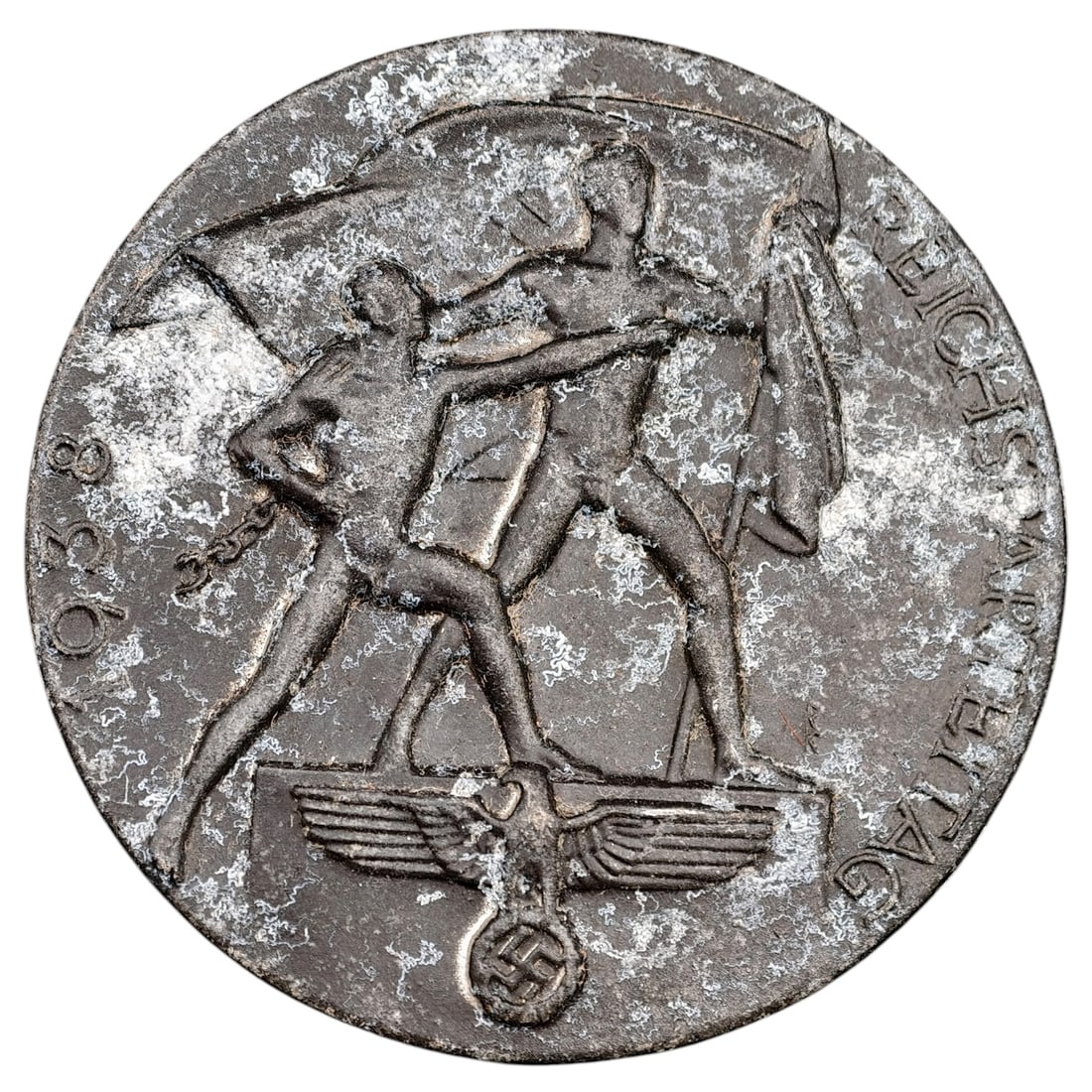 Third Reich Reichsparteitag Tinnie Badge: A pressed metal commemorative tinnie badge for the 1938 Reichsparteitag (Nazi Party Rally at Nuremberg), depicting two stylized male figures with flags standing above a Reichsadler with wreathed swast
