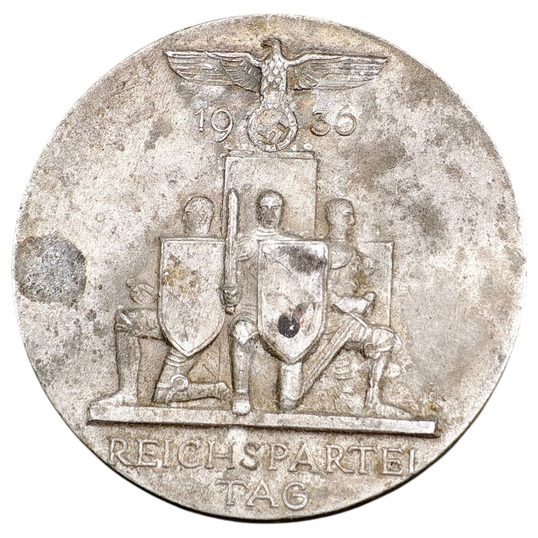 NSDAP Reichsparteitag 1936 Badge: Round tinnie badge commemorating the 1936 Reichsparteitag (Nazi Party Rally), featuring a Party eagle above a set of kneeling standard bearers with shields and date '1936', inscribed 'REICHSPARTEI TAG